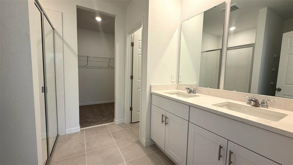 4543 Sidesaddle Trail St. Cloud, FL 34772 - Photo 9 of 19 a bathroom with a double vanity sink and mirror