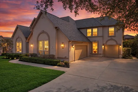 a view of a house with a large windows and a yard