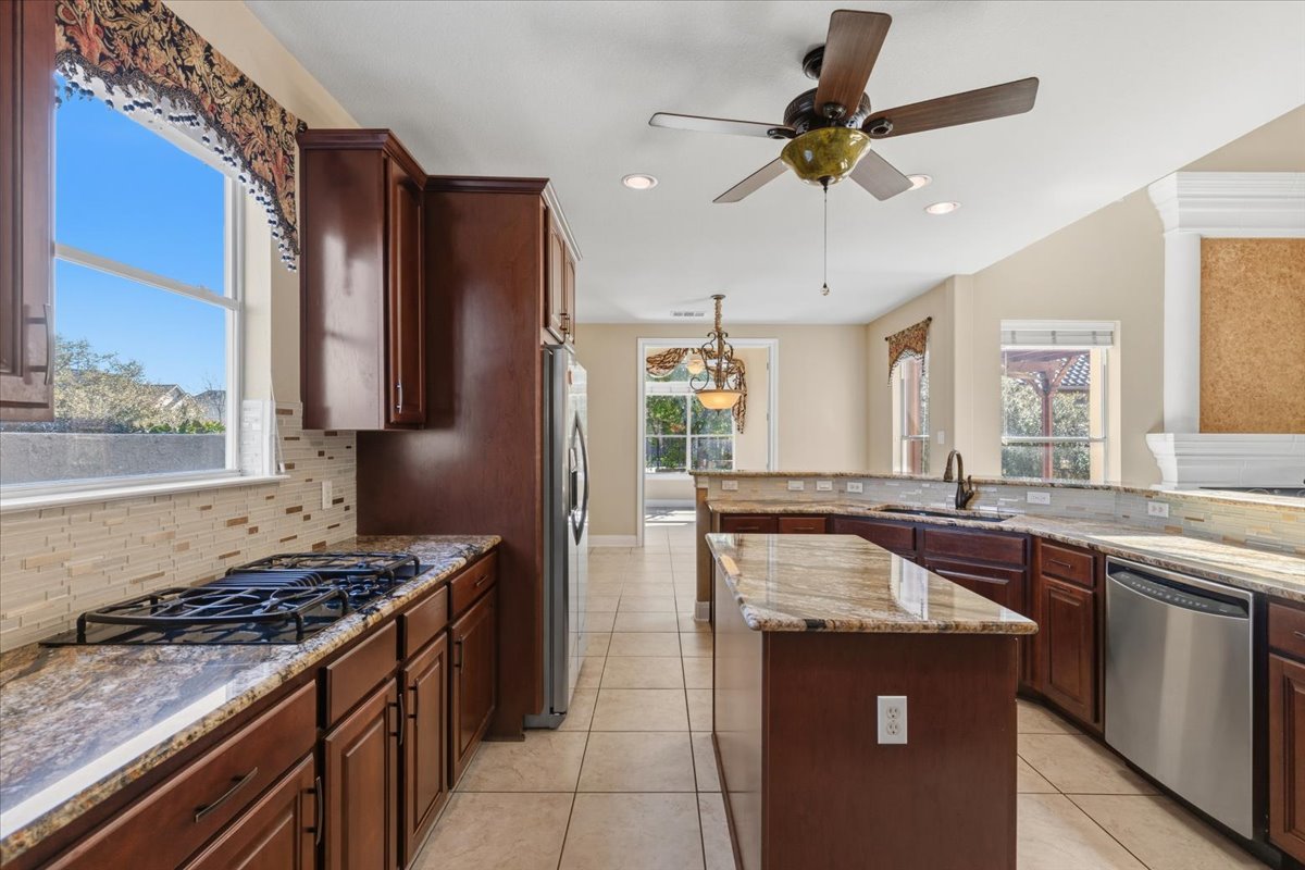 111 Whitley Drive Austin, TX 78738 - Photo 11 of 38 a kitchen with granite countertop a sink stove and refrigerator