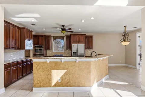a view of a kitchen with kitchen island a counter top space appliances and cabinets
