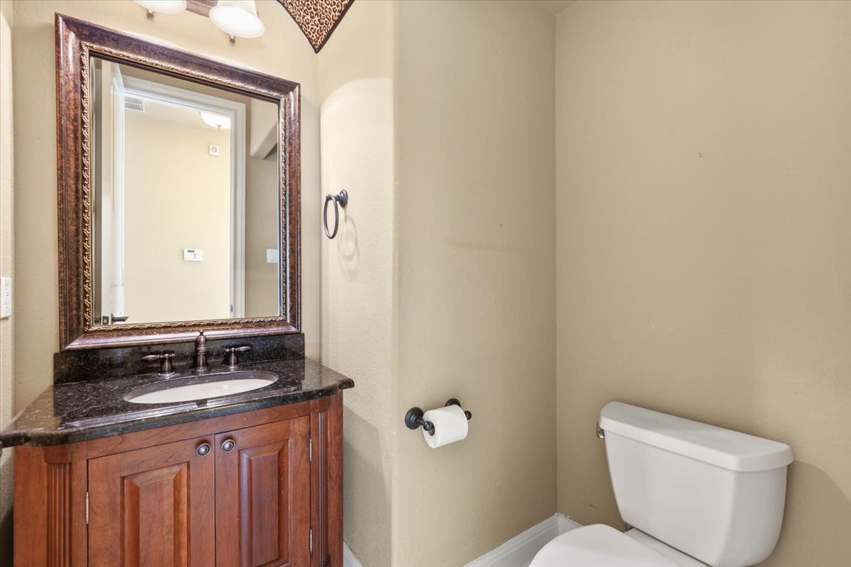 111 Whitley Drive Austin, TX 78738 - Photo 18 of 38 a bathroom with a granite countertop toilet a sink and mirror