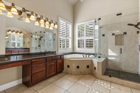 a spacious bathroom with a granite countertop tub sink and mirror