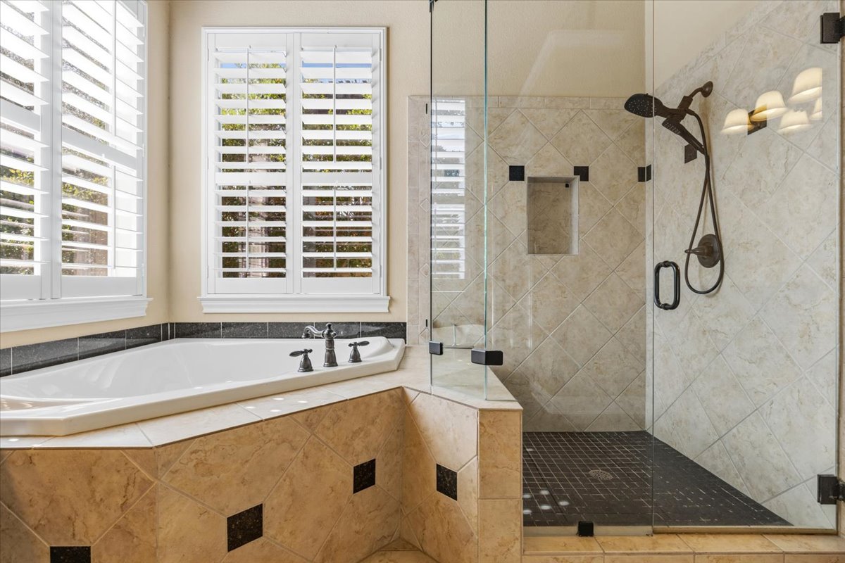 111 Whitley Drive Austin, TX 78738 - Photo 23 of 38 a bathroom with a tub a sink a window and a shower