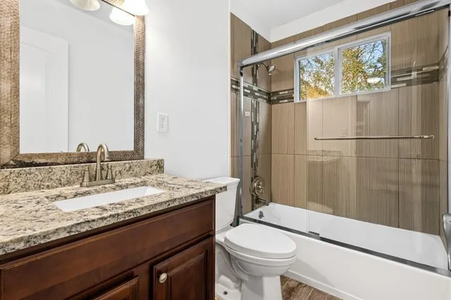 a bathroom with a granite countertop sink toilet and shower