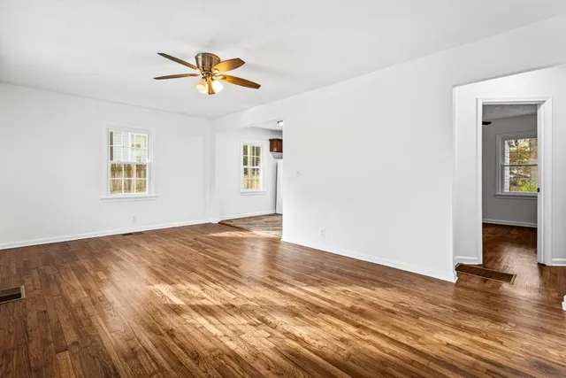 a view of a livingroom with wooden floor and a ceiling fan