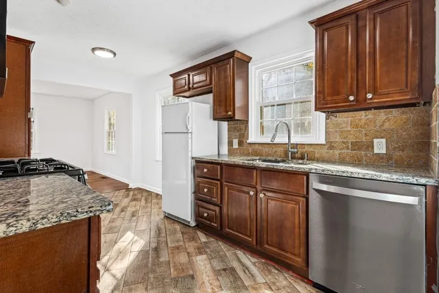 a kitchen with stainless steel appliances granite countertop a sink stove and refrigerator