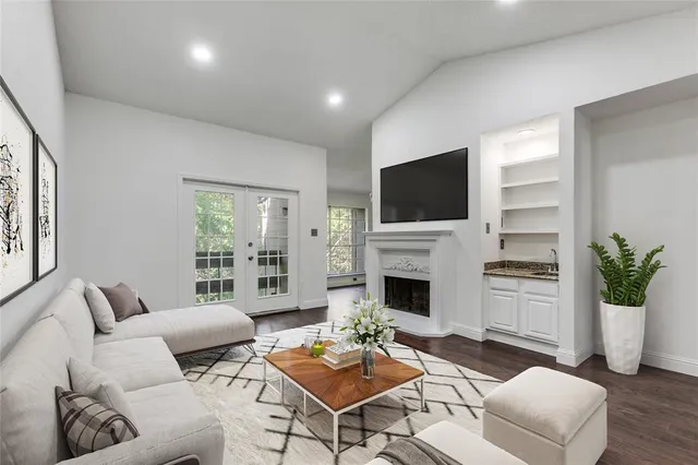 a living room with furniture a flat screen tv and a fireplace