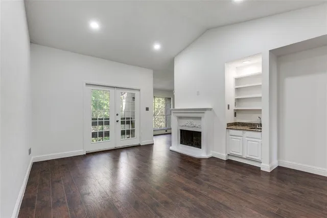 a view of an empty room with a fireplace and a window