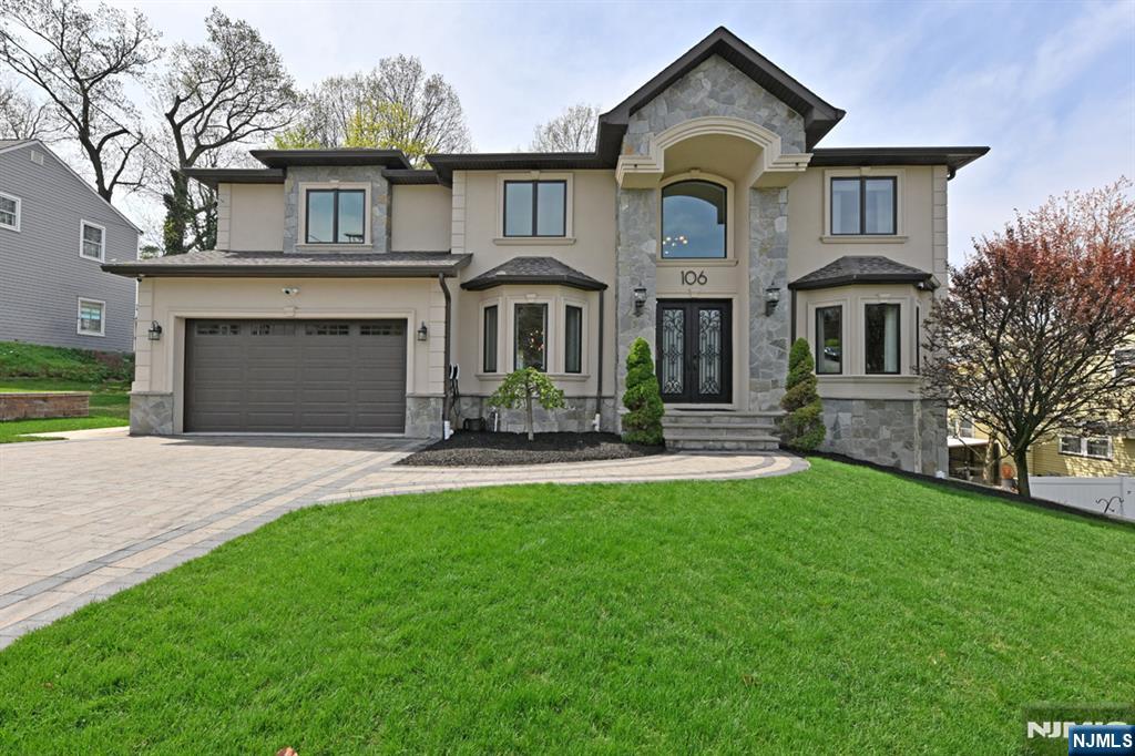 a front view of a house with a garden and yard