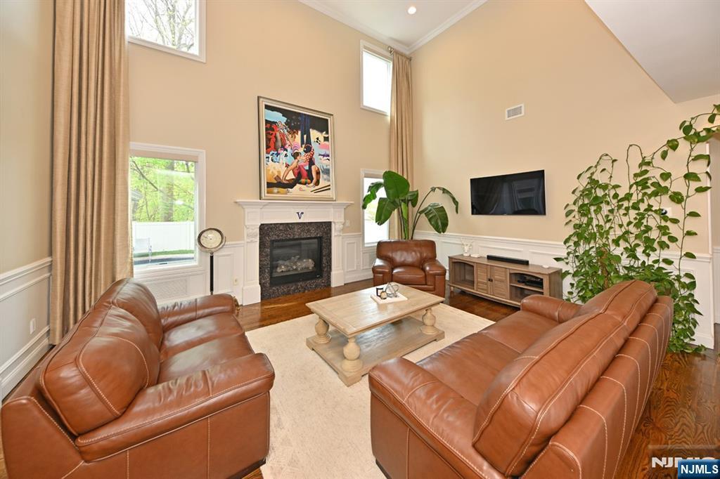 106 Arnot Place Paramus, NJ 07652 - Photo 11 of 48 a living room with furniture a fireplace and a flat screen tv
