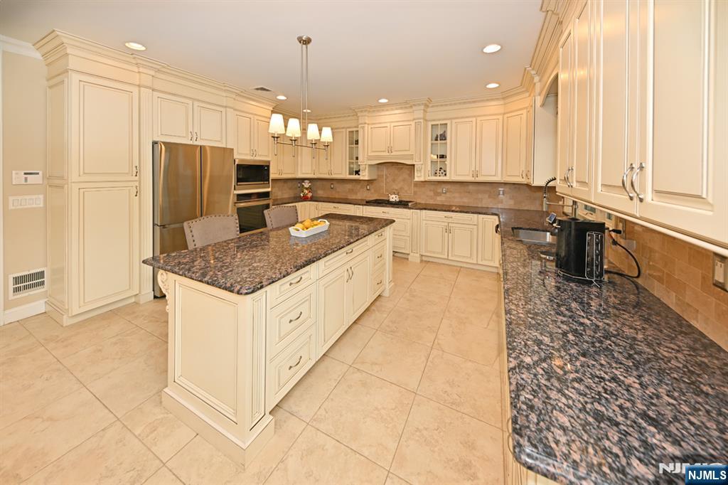 106 Arnot Place Paramus, NJ 07652 - Photo 15 of 48 a kitchen with stainless steel appliances granite countertop a sink and a refrigerator