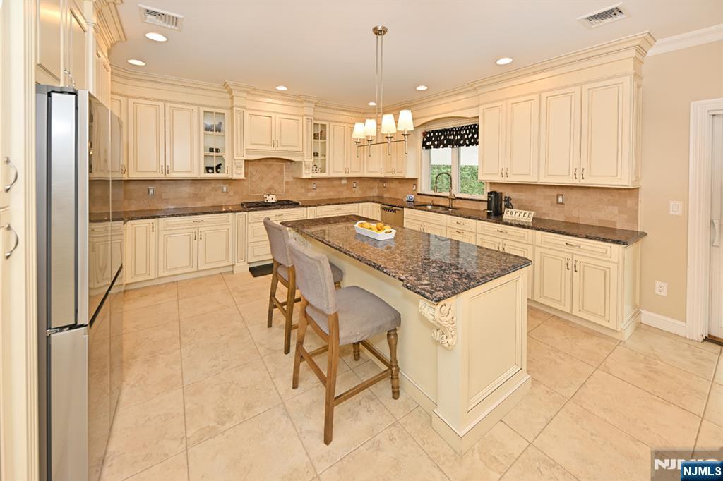 106 Arnot Place Paramus, NJ 07652 - Photo 16 of 48 a kitchen with stainless steel appliances granite countertop a sink and a refrigerator