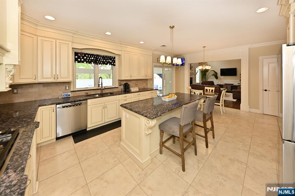106 Arnot Place Paramus, NJ 07652 - Photo 18 of 48 a kitchen with stainless steel appliances granite countertop a sink a stove a dining table and chairs