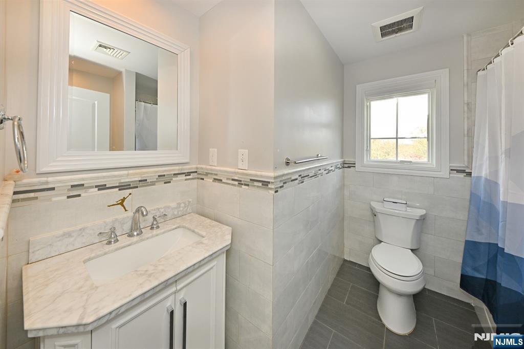 106 Arnot Place Paramus, NJ 07652 - Photo 28 of 48 a bathroom with a toilet sink and mirror