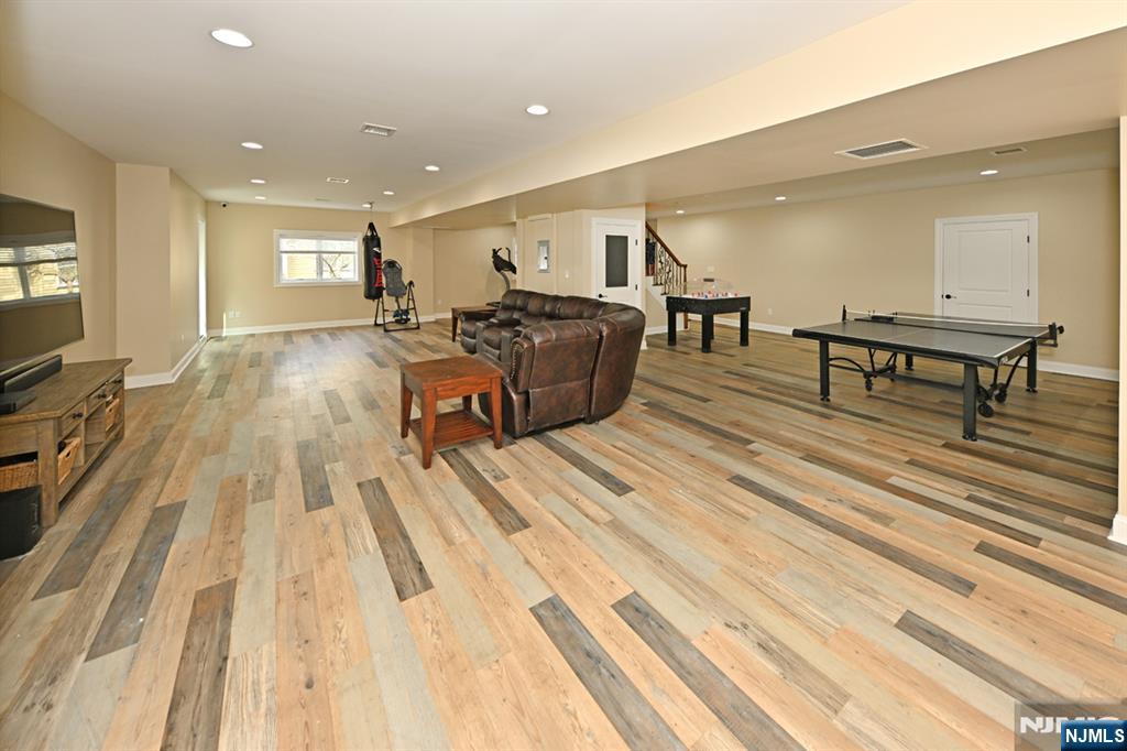 106 Arnot Place Paramus, NJ 07652 - Photo 30 of 48 a living room with furniture a wooden floor and a flat screen tv