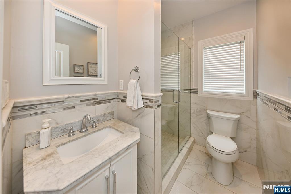 106 Arnot Place Paramus, NJ 07652 - Photo 9 of 48 a bathroom with a sink toilet and shower