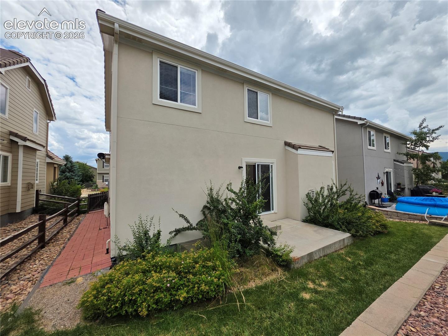 874 Diamond Rim Drive Colorado Springs, CO 80921 - Photo 27 of 28 Stucco exterior with multiple windows and a sliding glass door