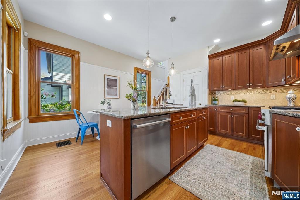 215 Inwood Avenue Montclair, NJ 07043 - Photo 23 of 50 a kitchen with stainless steel appliances granite countertop wooden cabinets a dining table and chairs