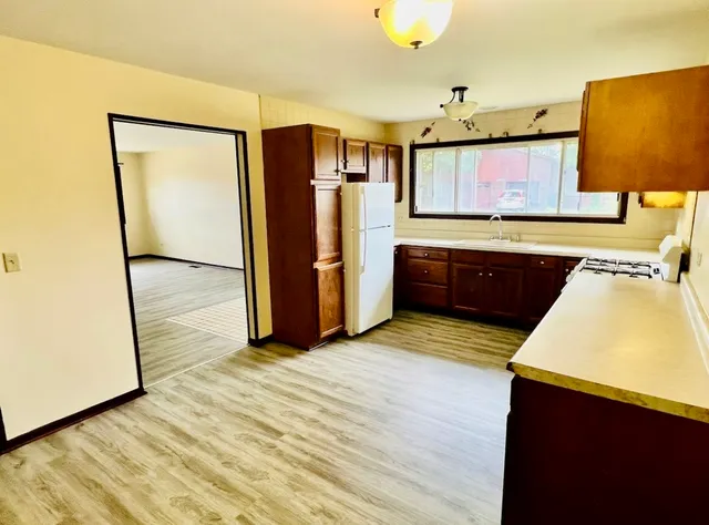 a kitchen with stainless steel appliances granite countertop a refrigerator a sink and a stove