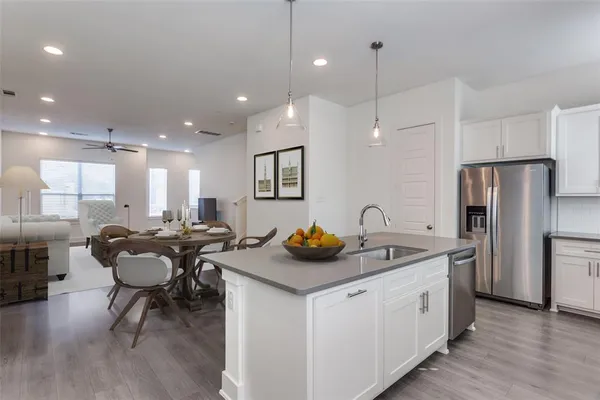 a kitchen with stainless steel appliances granite countertop a sink and a refrigerator