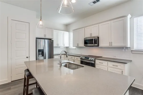 a kitchen with kitchen island a sink appliances and cabinets