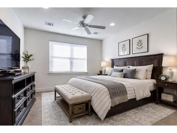 a spacious bedroom with a bed and a chandelier