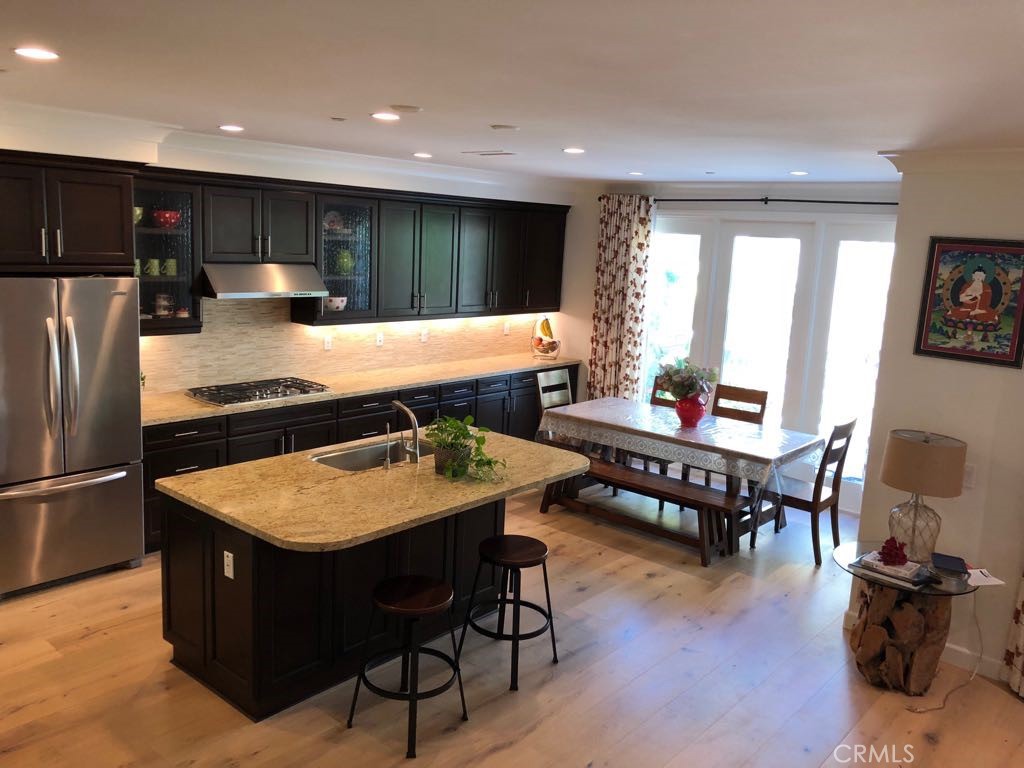 88 Lupari Irvine, CA 92618 - Photo 3 of 33 a kitchen with stainless steel appliances granite countertop a refrigerator a sink dishwasher a dining table and chairs with wooden floor