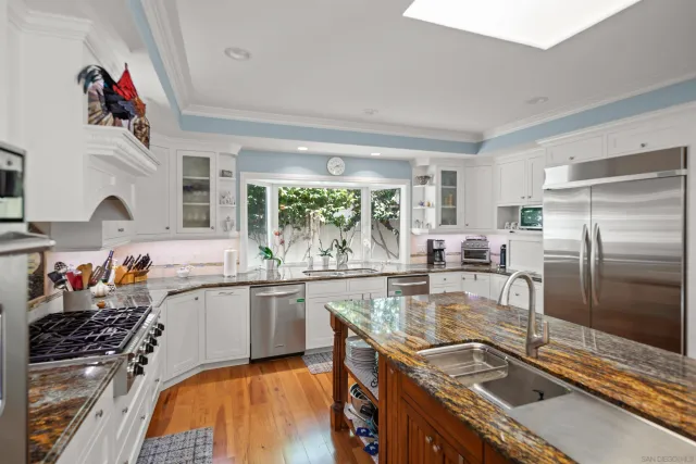 a kitchen with granite countertop a sink a stove and cabinets