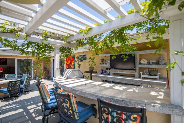 a patio with a table and chairs and potted plants
