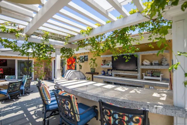 a patio with a table and chairs and potted plants