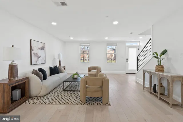 a living room with furniture a couch and a bookshelf with wooden floor