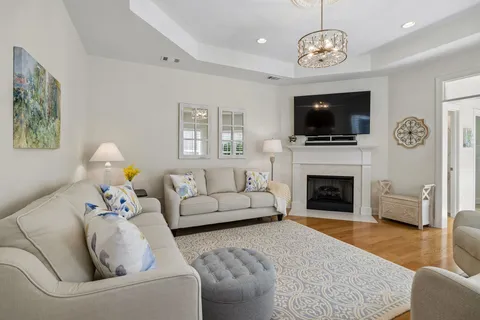 a living room with furniture a flat screen tv and a fireplace