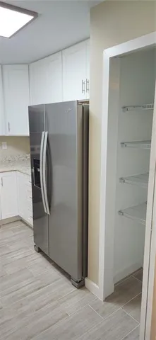 a view of a kitchen with refrigerator and cabinet