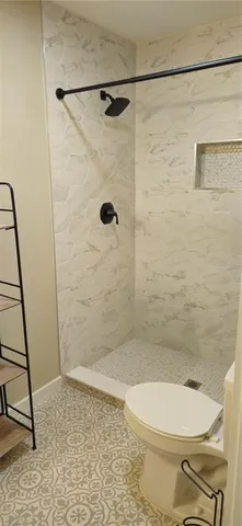 a bathroom with a toilet and a shower