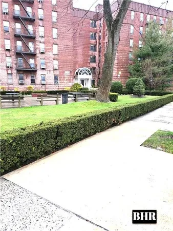 a view of a big building with a big yard and large trees