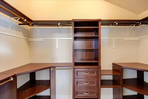 a view of walk in closet with clothes and shoes