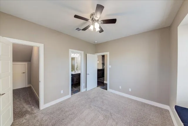 an empty room with closet and a ceiling fan