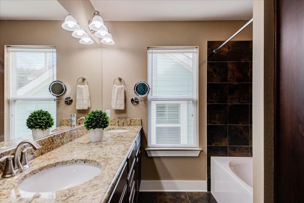12212 Tawny Farms Road, Unit 142 Austin, TX 78748 - Photo 25 of 38 a bathroom with a granite countertop sink and a mirror