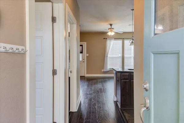 a view of a hallway with wooden floor and chandelier