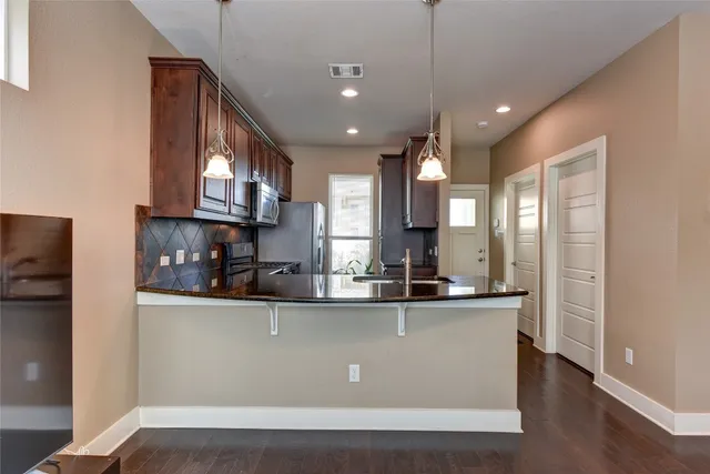 a kitchen with stainless steel appliances granite countertop a sink a stove and a refrigerator