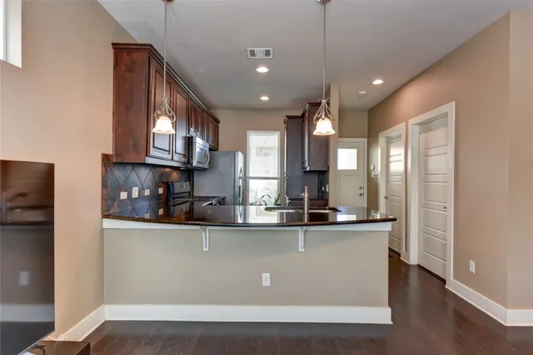 a kitchen with stainless steel appliances granite countertop a sink a stove and a refrigerator