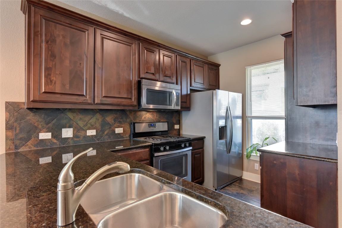 12212 Tawny Farms Road, Unit 142 Austin, TX 78748 - Photo 10 of 38 a kitchen with a refrigerator a microwave and sink