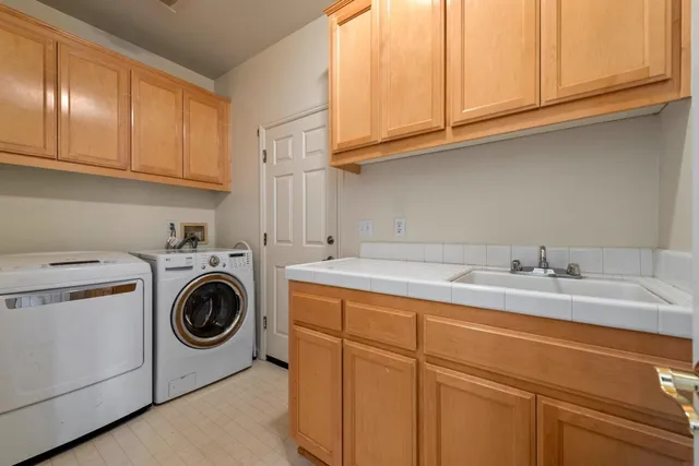 a utility room with sink dryer and washer