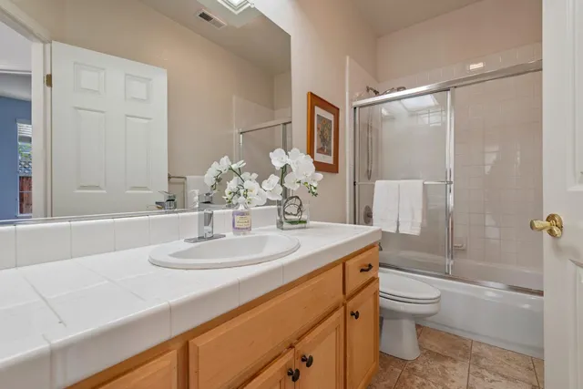 a bathroom with a sink toilet vanity and shower