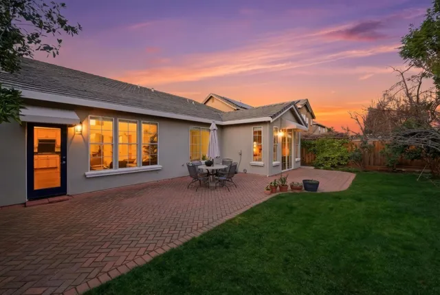 a view of a house with patio and a garden