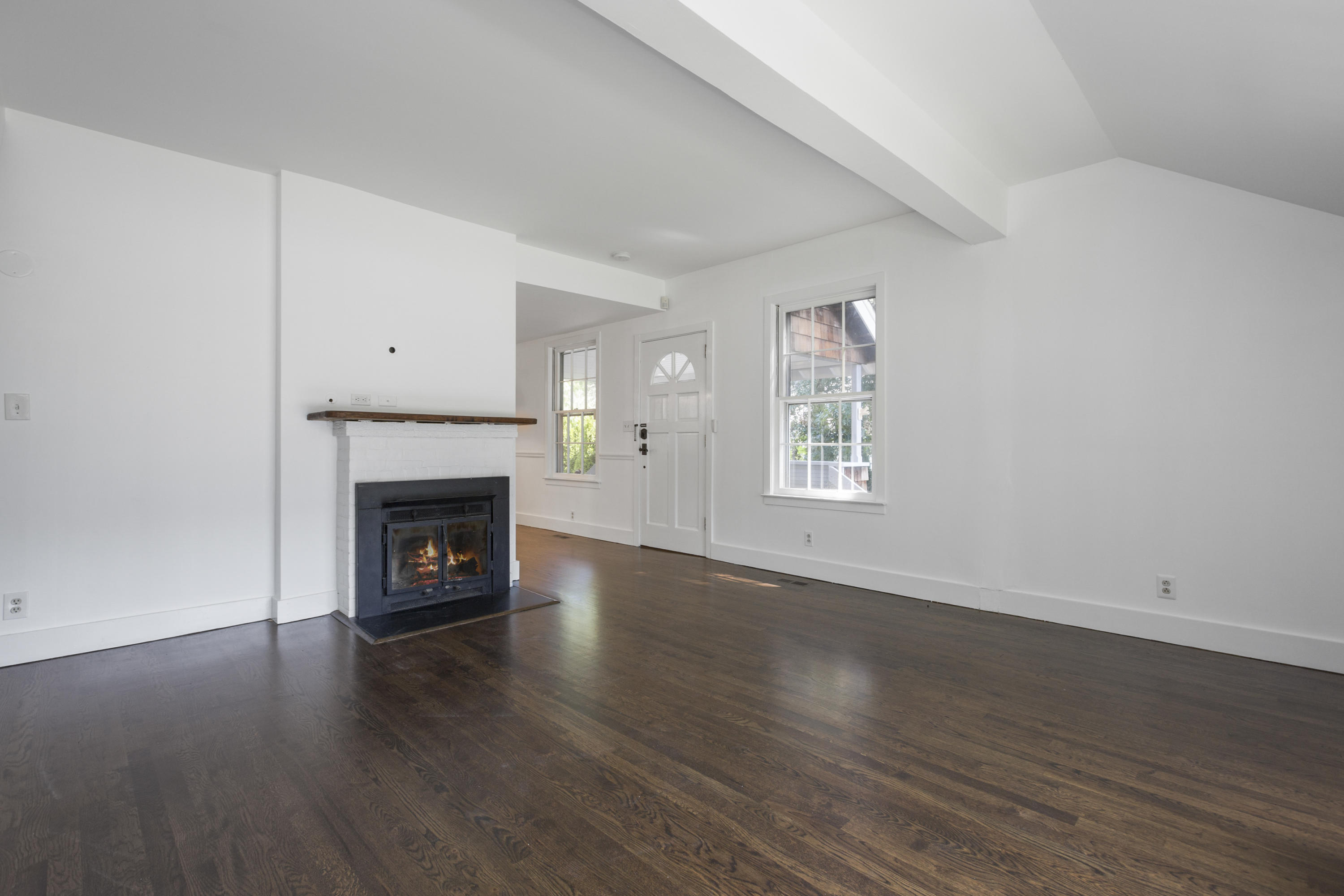 28 Edgewood Road Darien, CT 06820 - Photo 8 of 23 an empty room with wooden floor a fireplace and windows