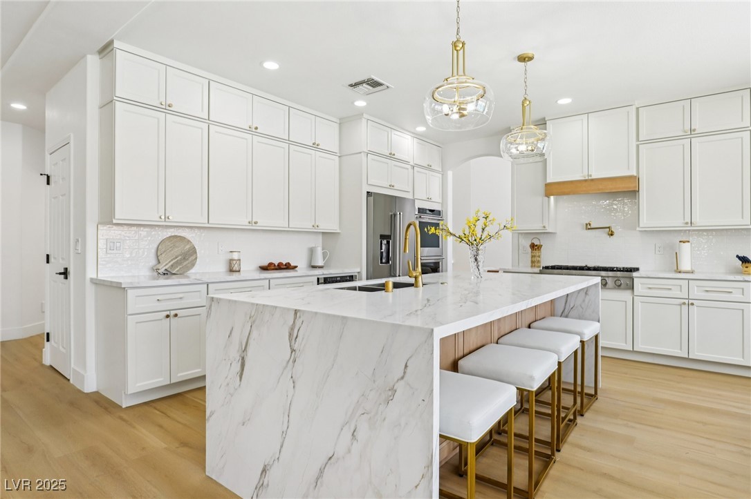 2469 Sun Reef Road Las Vegas, NV 89128 - Photo 35 of 93 Kitchen with recessed lighting, decorative backsplash, light wood-type flooring, and white cabinets