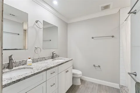a bathroom with a granite countertop sink a toilet and shower