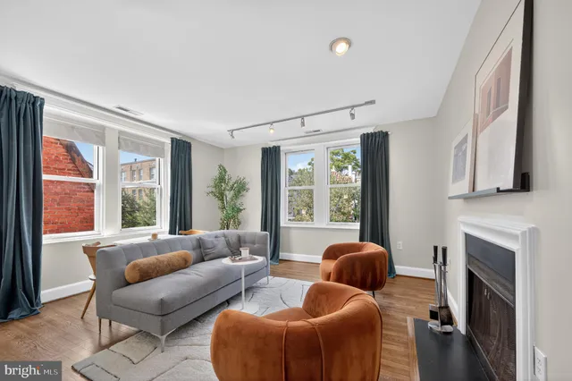 a living room with furniture a fireplace and a large window