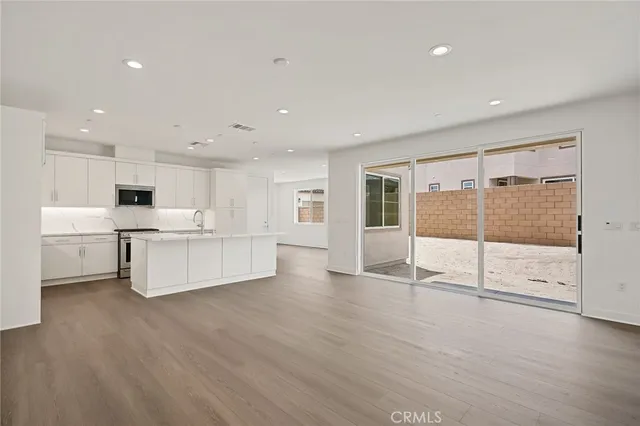 a large white kitchen with large windows and white cabinets